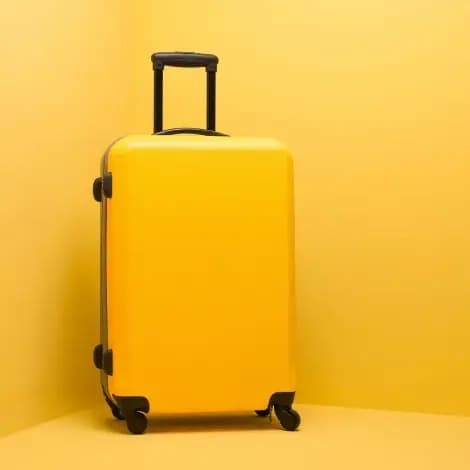 Yellow hard-shell luggage, representative of the bags category Ainomi is developing
